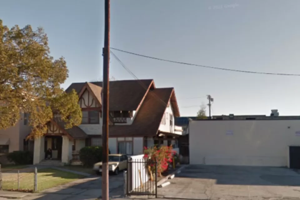 Google street view of late Victorian home in Harvard Heights neighborhood of Los Angeles, with one-story commercial building next door.